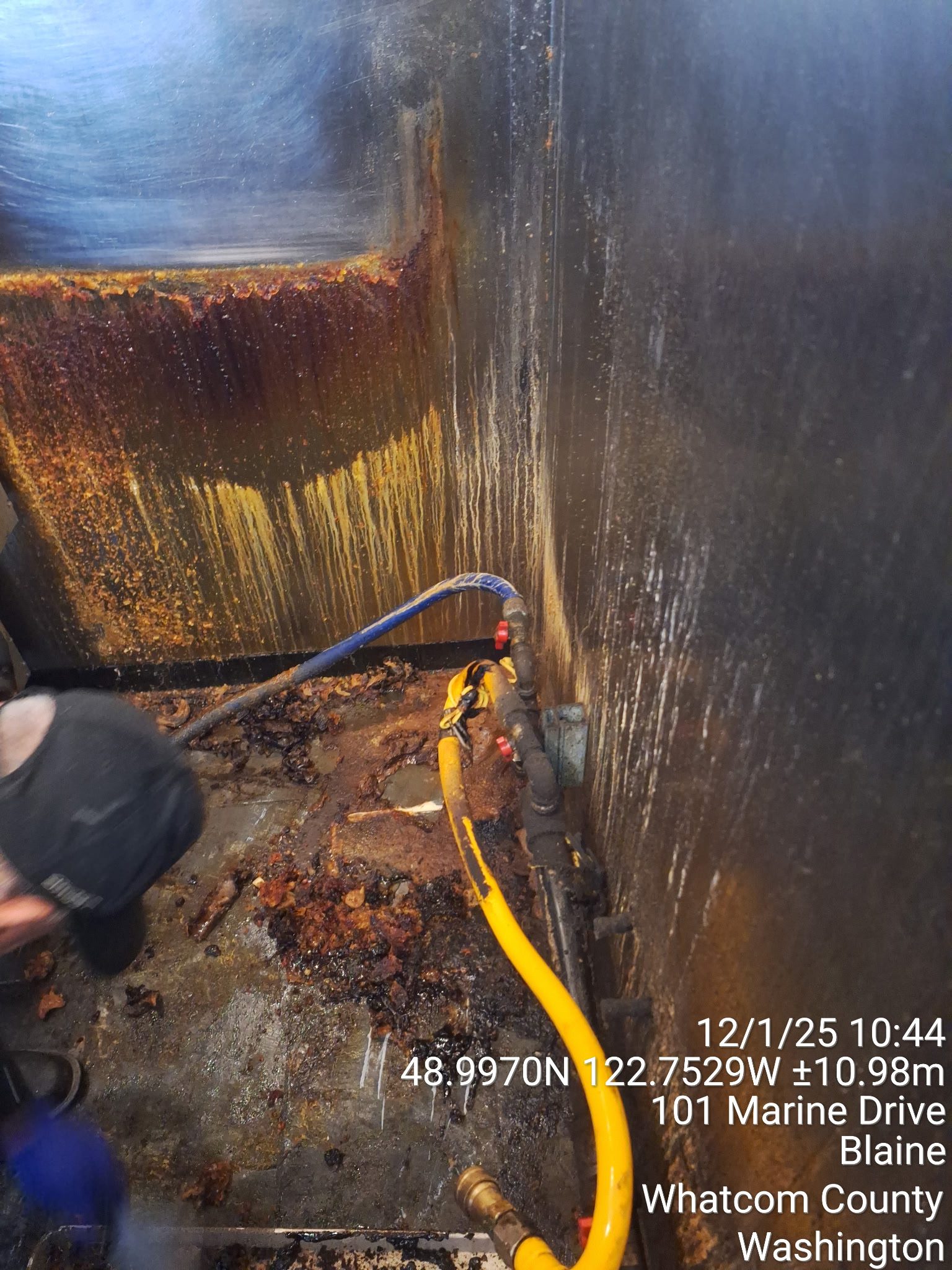 Worker using a cutting torch on a metal structure in a confined space.