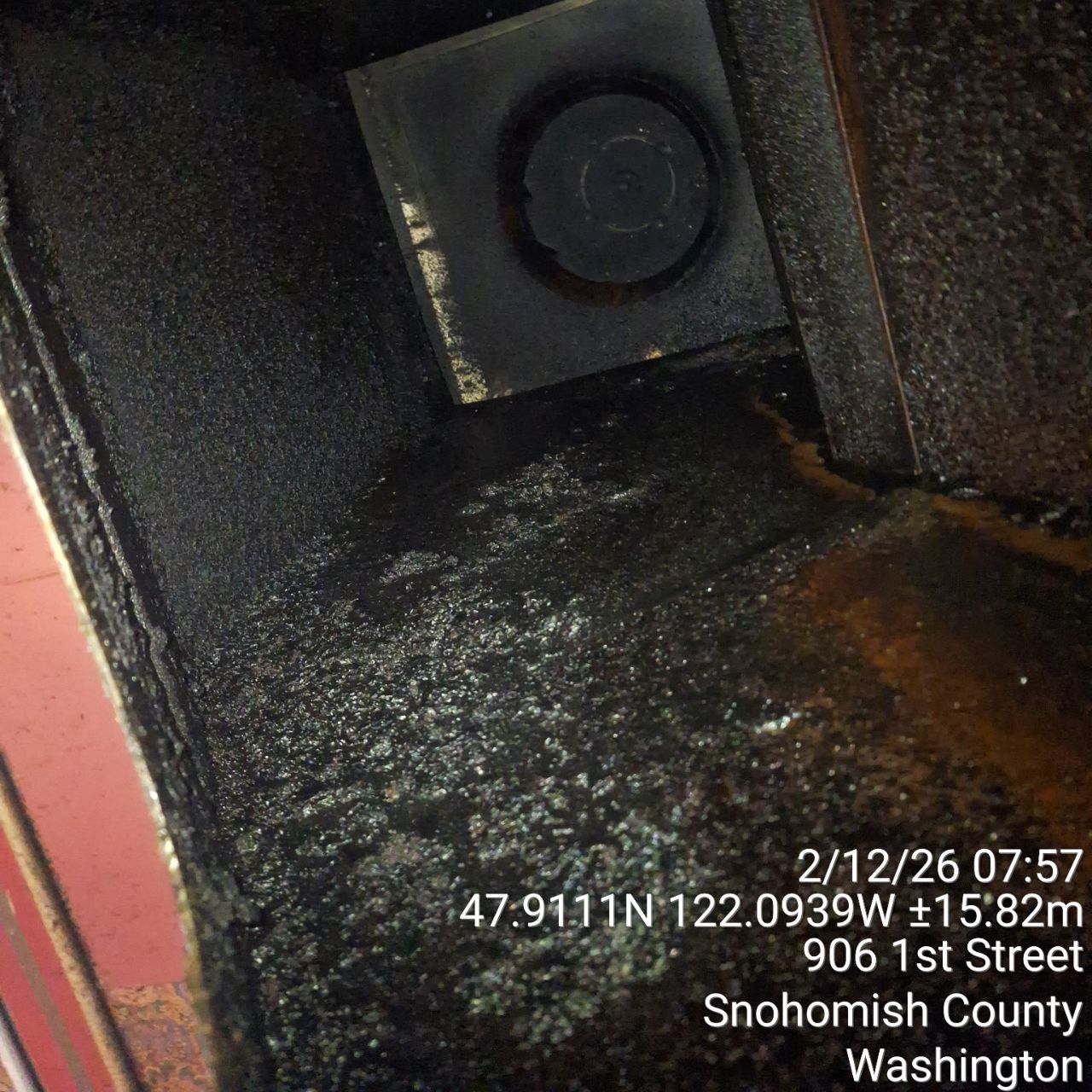 Inside view of a dirty ventilation duct with buildup and a fan at the end.