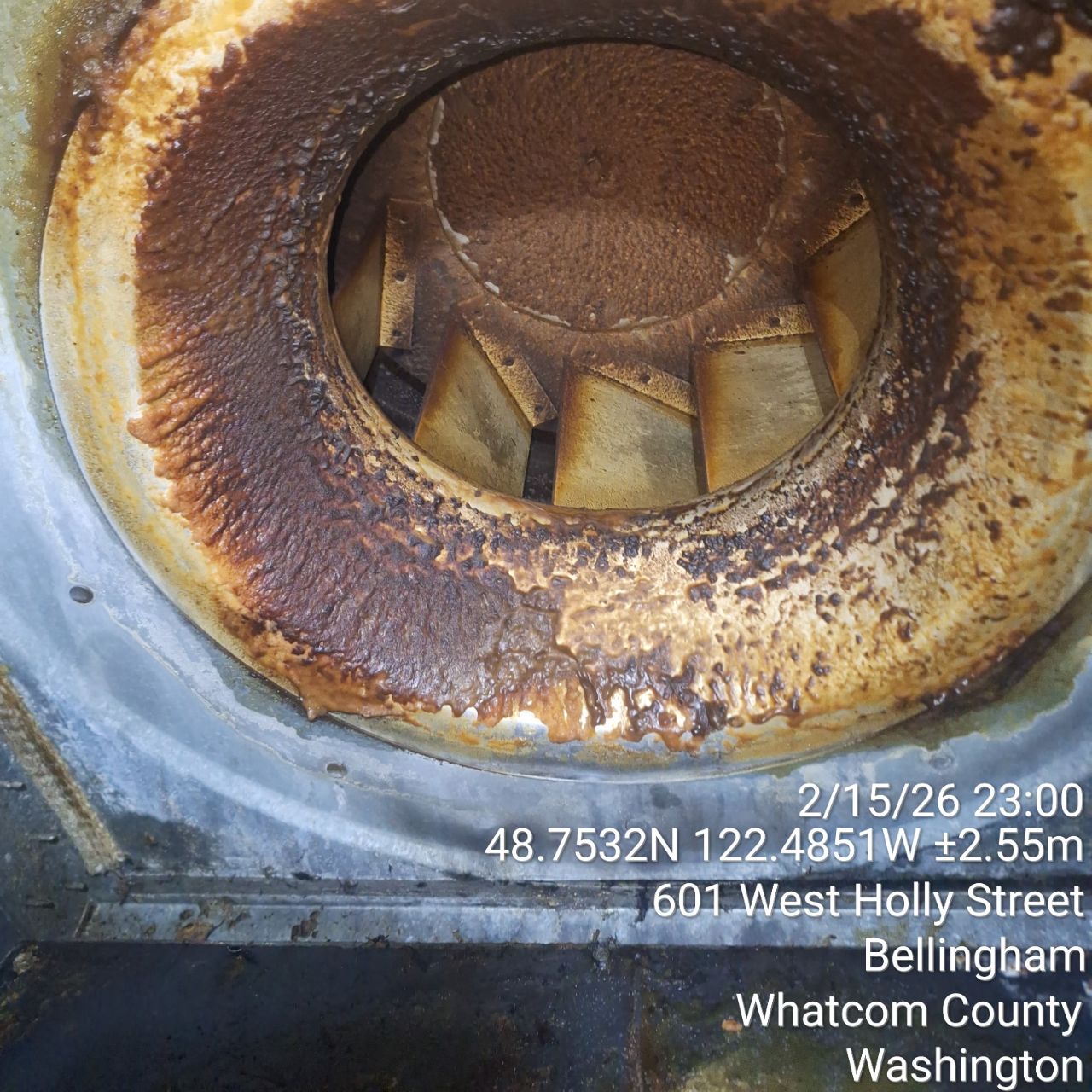 Rusty metal pipe opening with visible interior buildup.