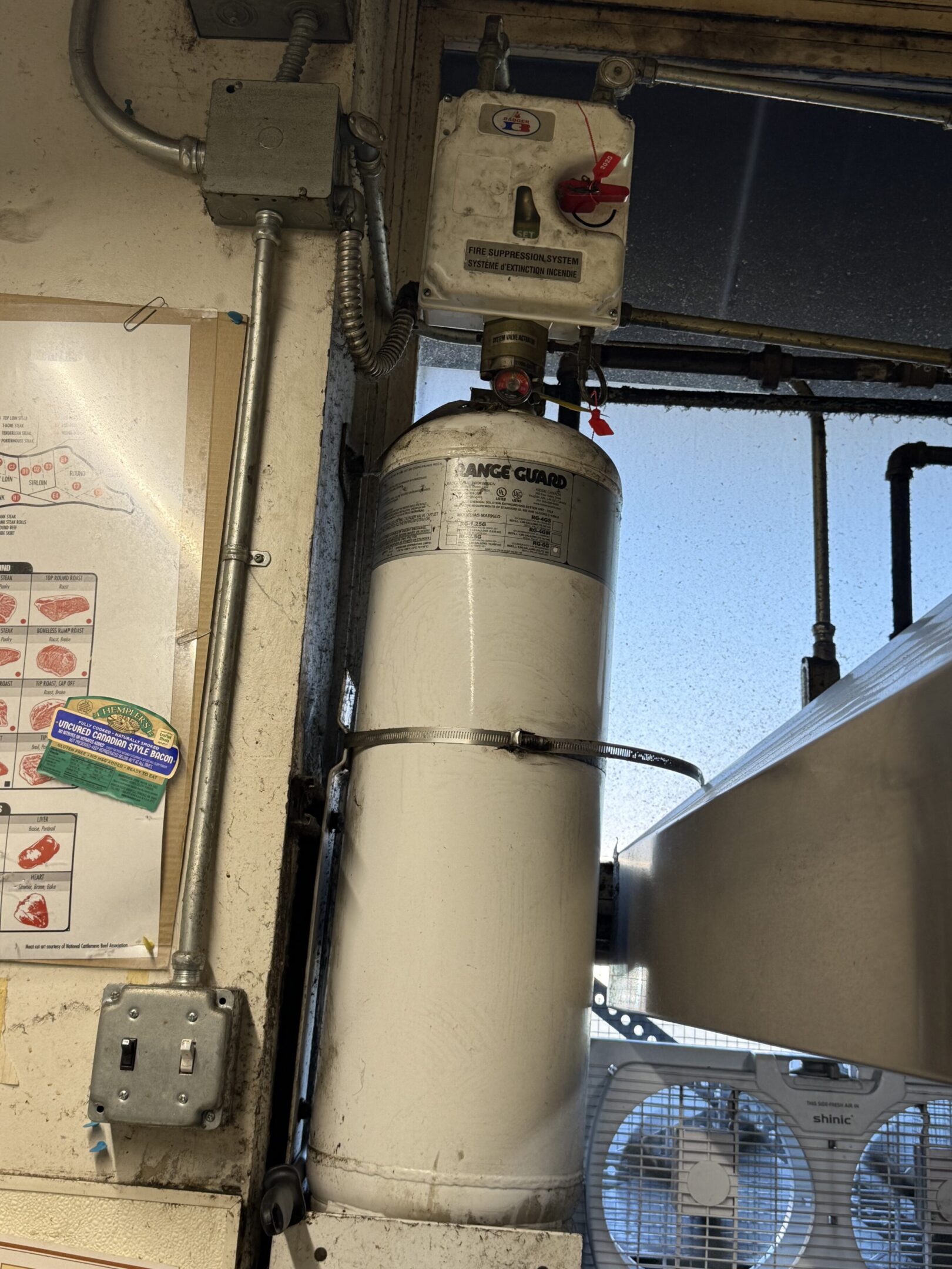 A tall industrial water heater with pipes and control panel.