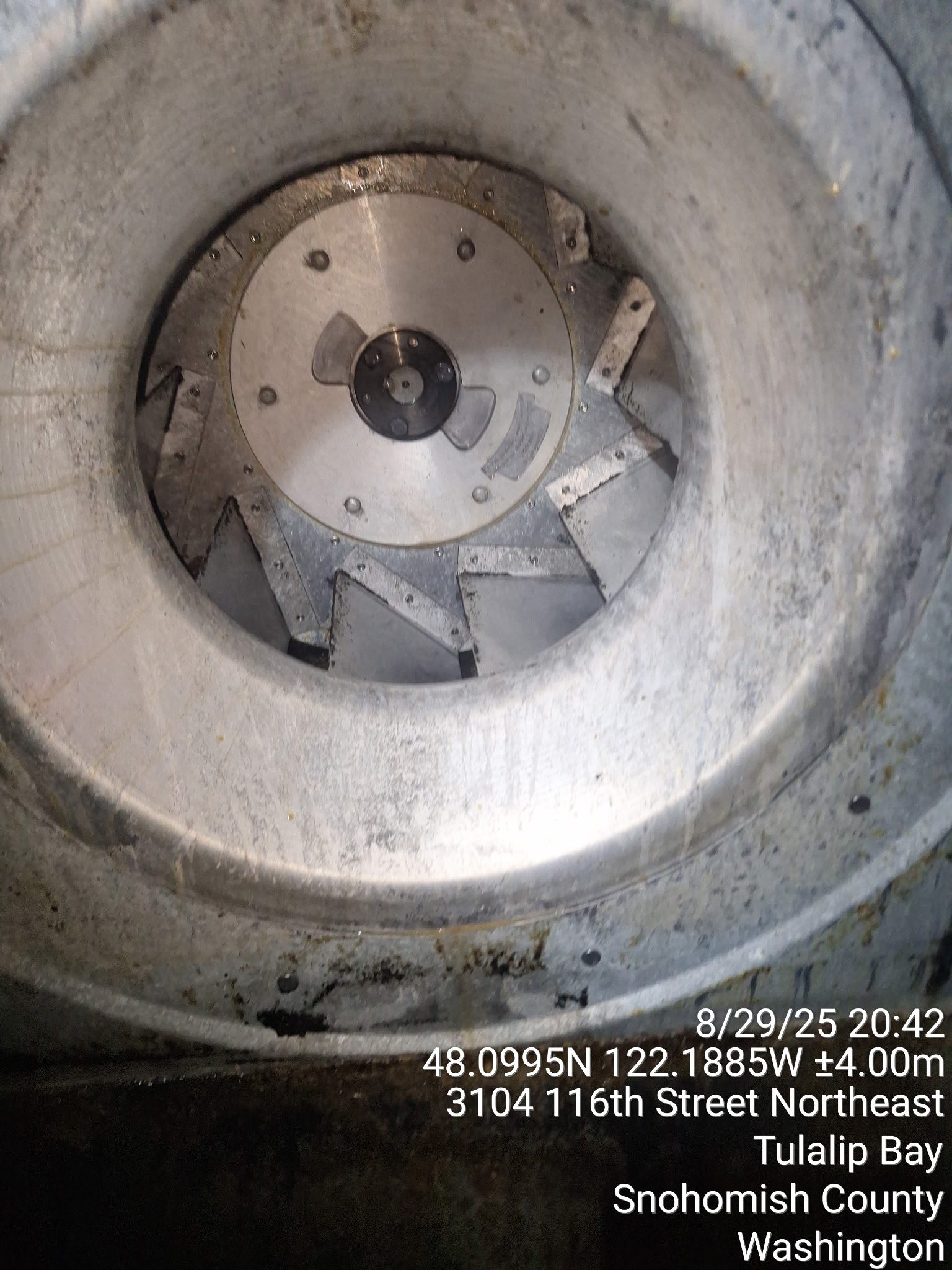 Close-up of an industrial fan or blower inside a cylindrical housing.