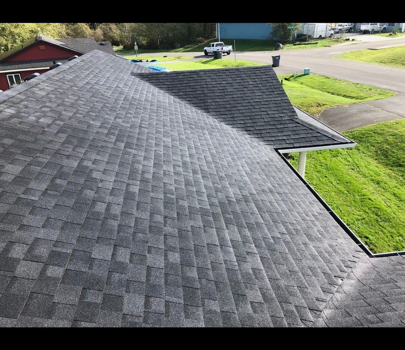 Newly installed grey asphalt shingle roof on a house.