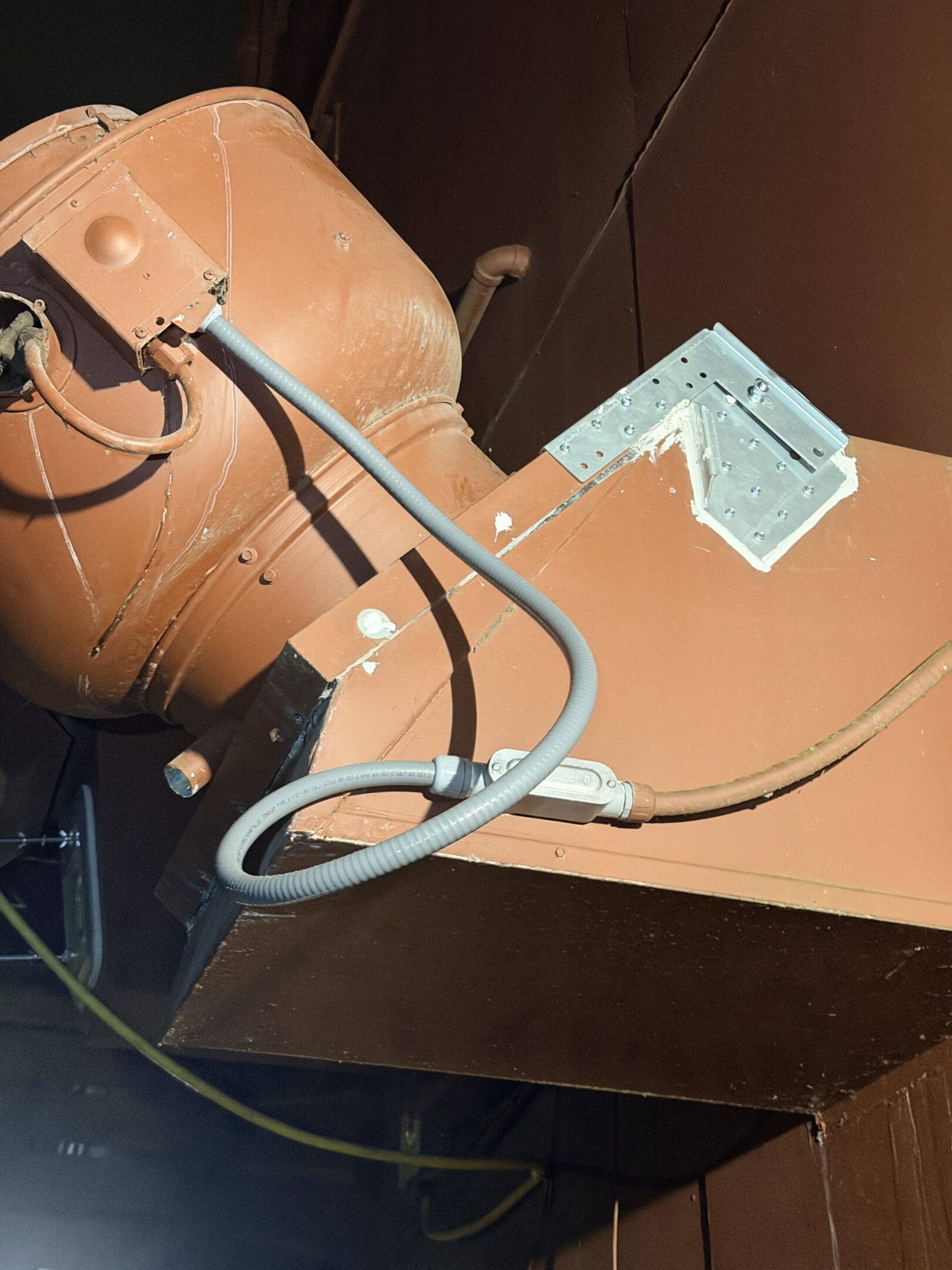 A brown pot with a hose and a small white label.