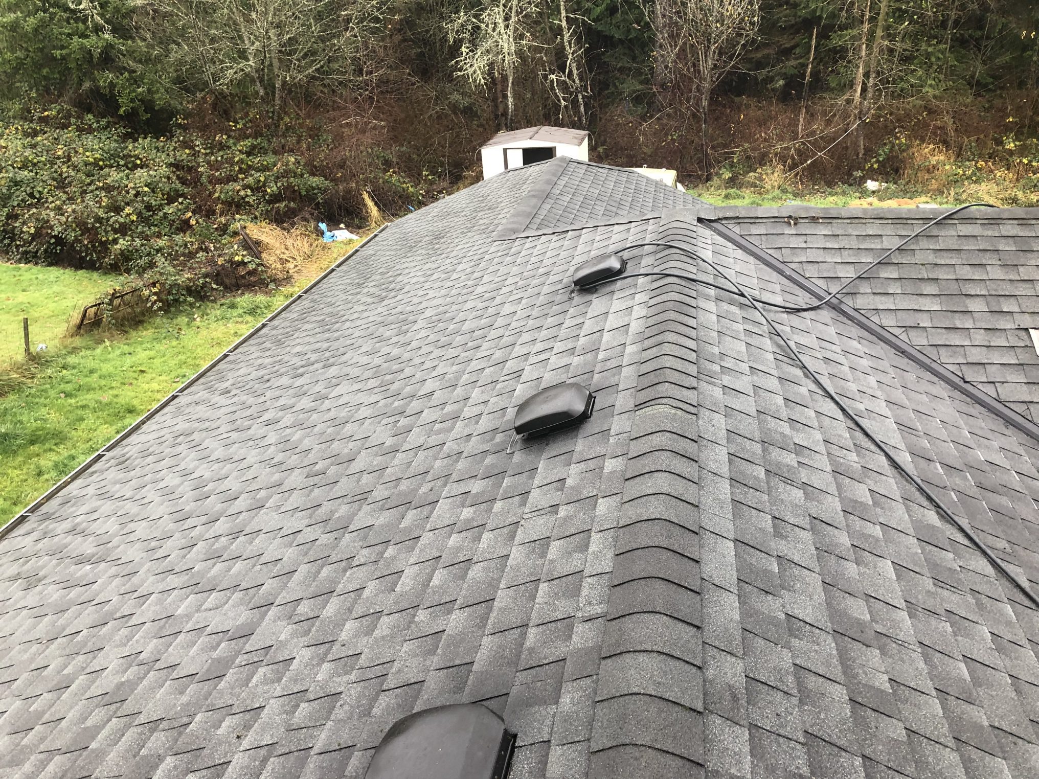Newly installed gray asphalt shingle roof on a house.