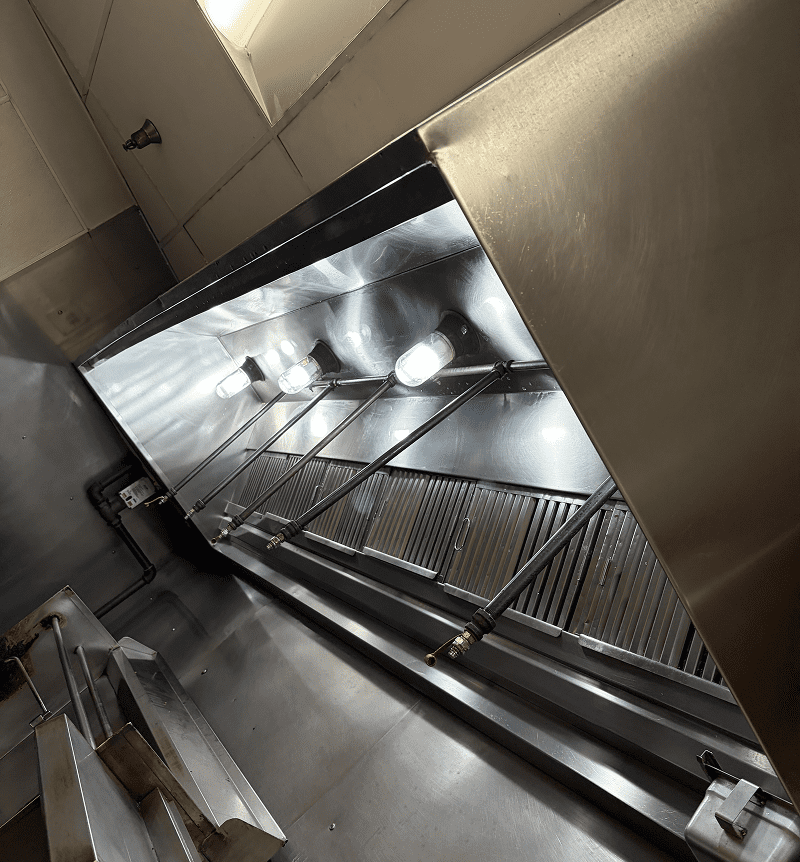 Long escalator inside a building with metal railings and lights.