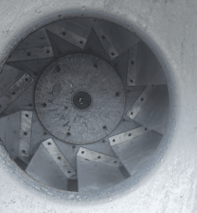Close-up of a large industrial fan or turbine inside a cylindrical housing.