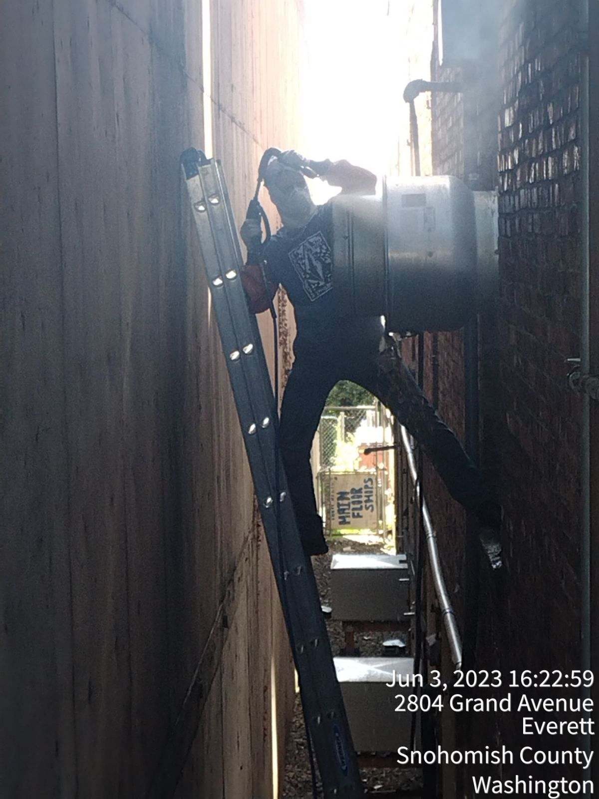 Person climbing a ladder between two narrow walls.