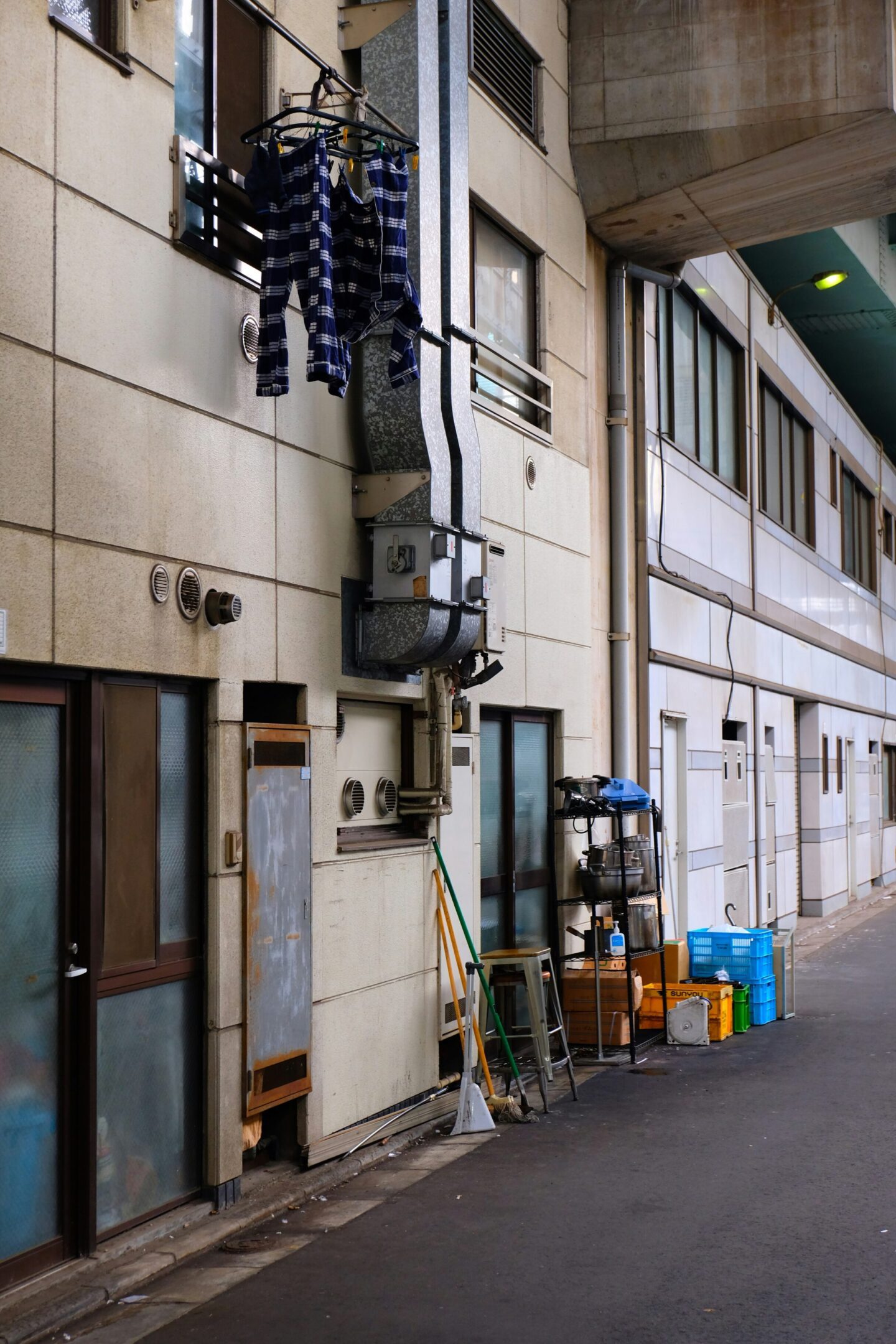 Industrial hallway with equipment and storage bins.