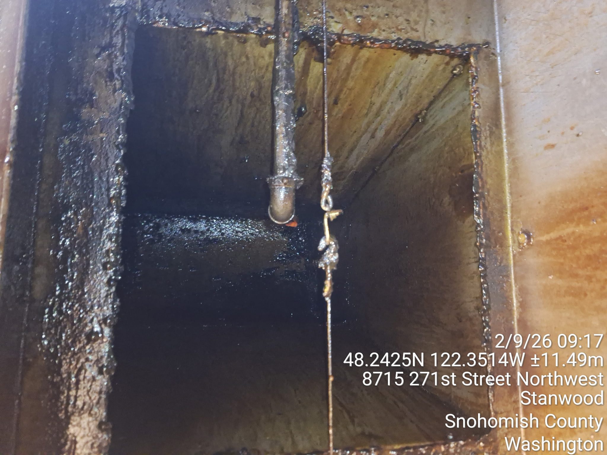 Rusty industrial tank interior with pipes and buildup.