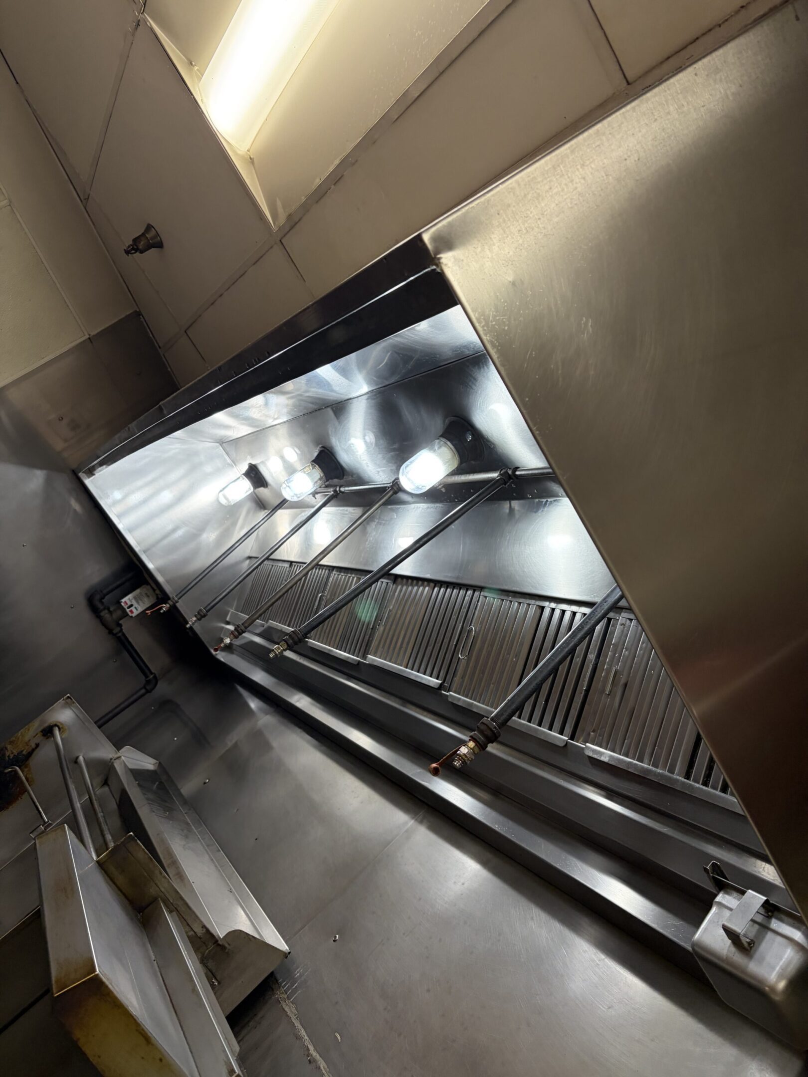 Empty escalator in a modern indoor setting with metallic and glass elements.