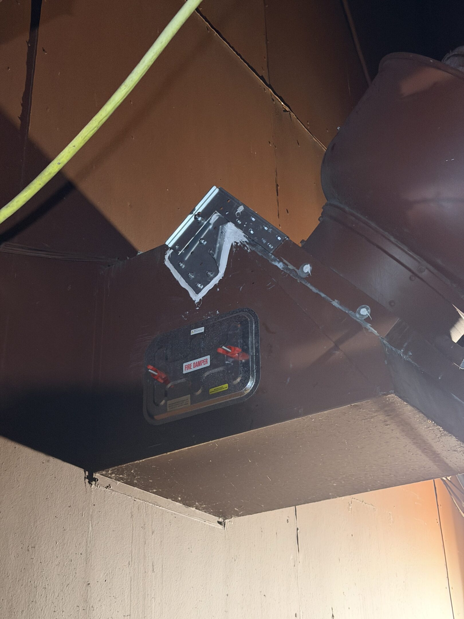 A black microphone on a stand in a room with a low ceiling.