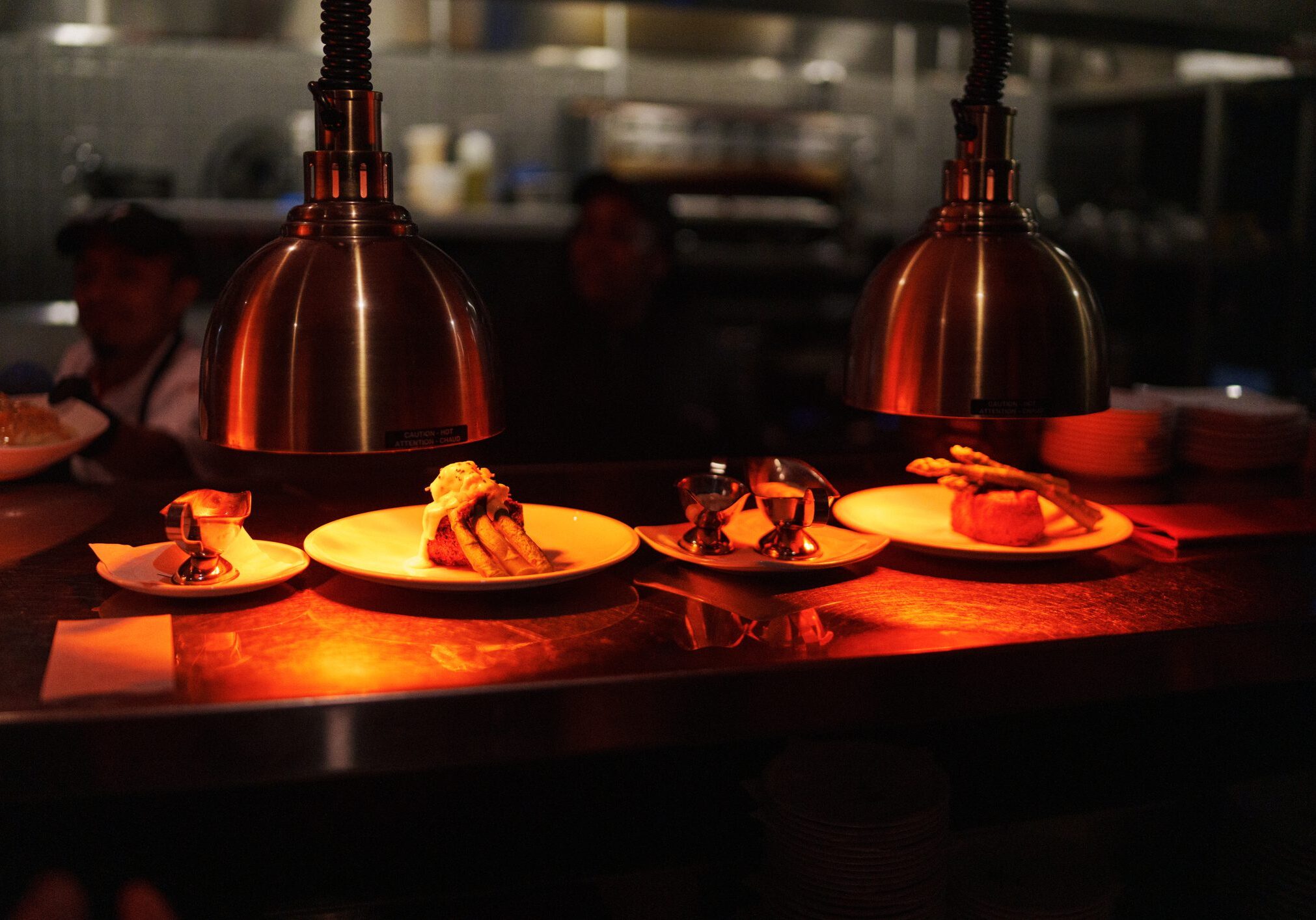 Warmly lit plates of gourmet food ready for serving.